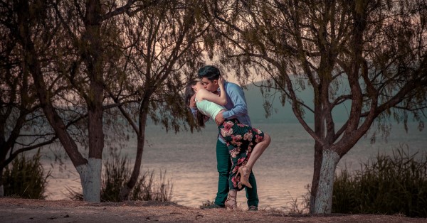 Couple kissing by a lake.